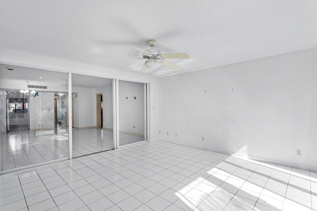 unfurnished room featuring a ceiling fan, visible vents, a textured ceiling, and light tile patterned floors