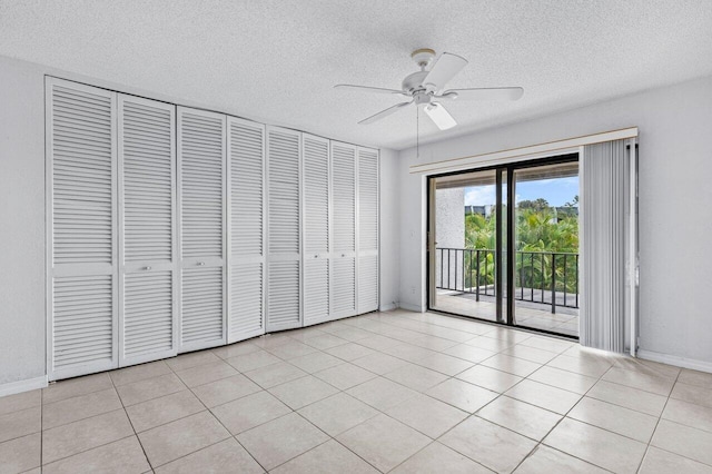 unfurnished bedroom featuring a textured ceiling, light tile patterned flooring, baseboards, and access to exterior