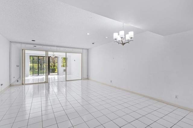 spare room featuring light tile patterned floors, a textured ceiling, baseboards, and a notable chandelier