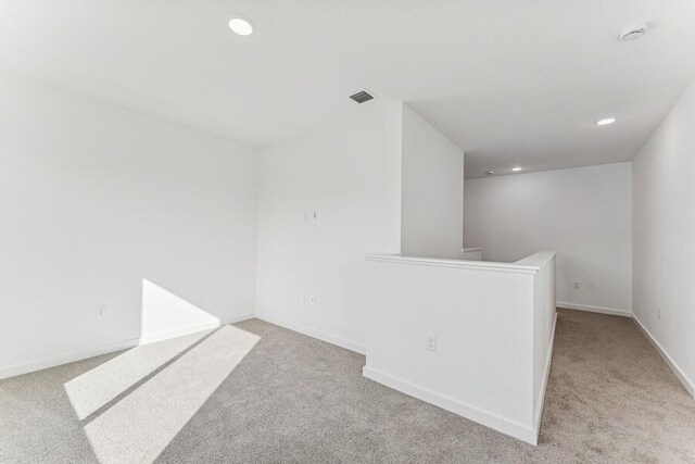 carpeted empty room with recessed lighting, visible vents, and baseboards