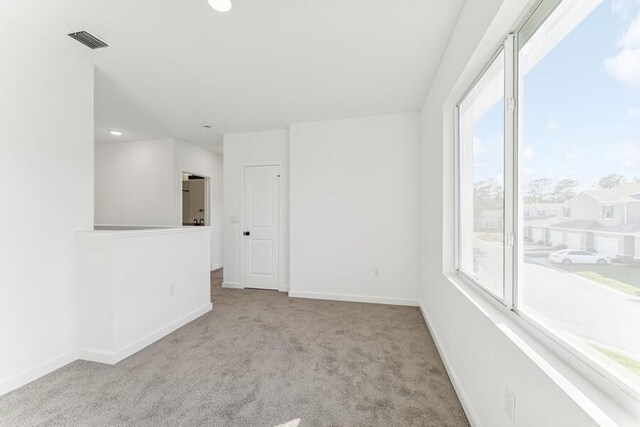 carpeted empty room featuring visible vents and baseboards