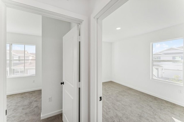 hall with carpet floors, baseboards, and recessed lighting