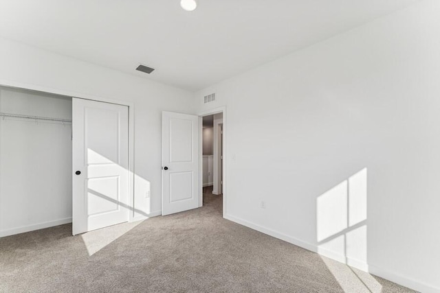 unfurnished bedroom with baseboards, a closet, visible vents, and carpet flooring