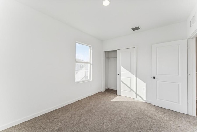 unfurnished bedroom with baseboards, a closet, visible vents, and carpet flooring