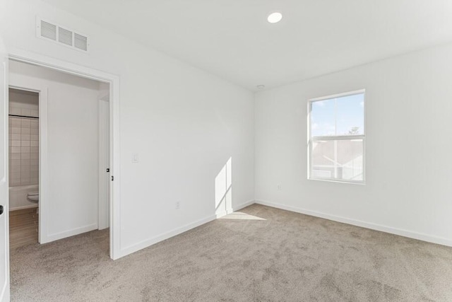 empty room featuring recessed lighting, carpet flooring, visible vents, and baseboards