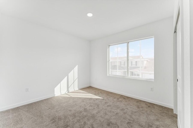 unfurnished room featuring carpet and baseboards