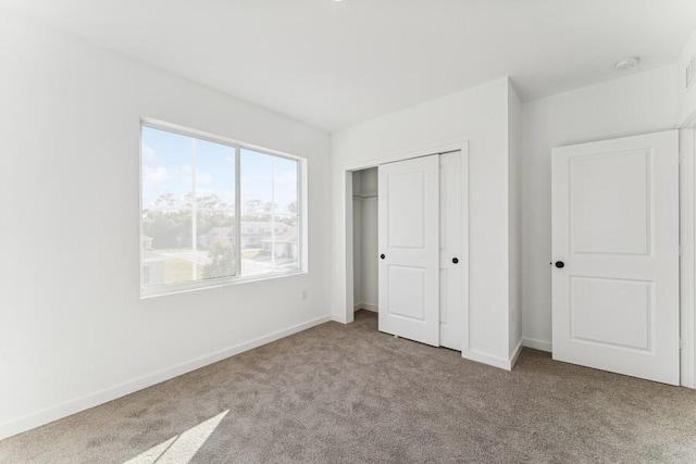 unfurnished bedroom with a closet, baseboards, and carpet flooring