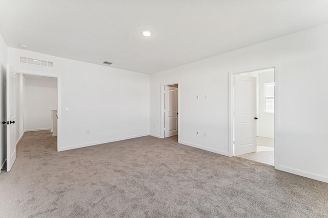 unfurnished bedroom with baseboards, visible vents, and light colored carpet