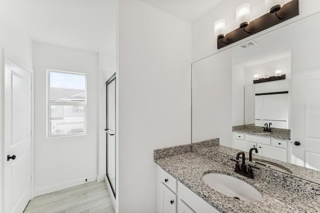 full bathroom featuring a shower stall, a sink, and wood finished floors