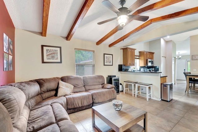 living room with lofted ceiling with beams, light tile patterned floors, ceiling fan, and a textured ceiling