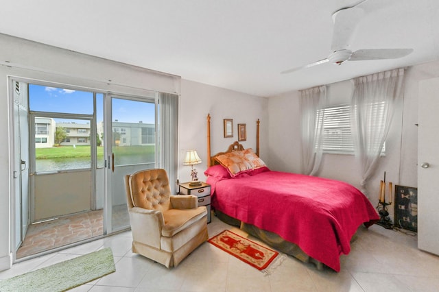 bedroom with a water view, access to exterior, light tile patterned floors, and a ceiling fan