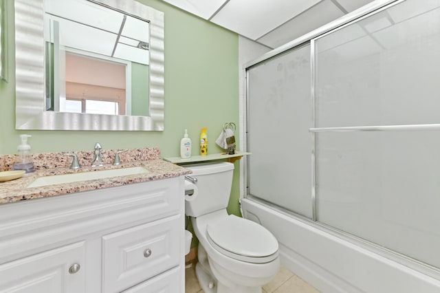 full bath with combined bath / shower with glass door, vanity, toilet, and tile patterned floors