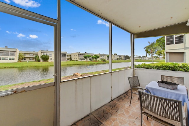 unfurnished sunroom with a residential view and a water view