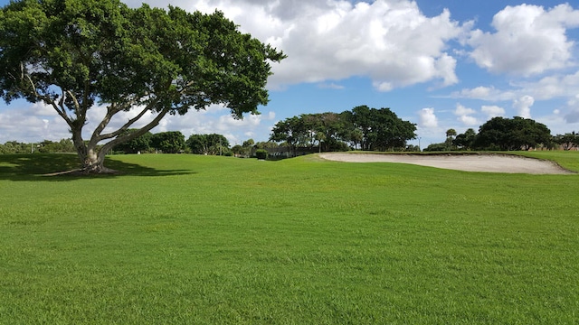 view of community with view of golf course and a yard