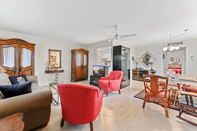 living room with ceiling fan with notable chandelier and light tile patterned floors