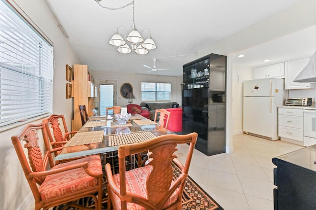 dining room featuring light tile patterned floors, an inviting chandelier, baseboards, and a toaster