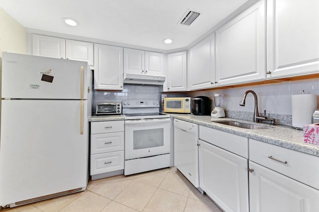 kitchen featuring white appliances, white cabinetry, a sink, and under cabinet range hood