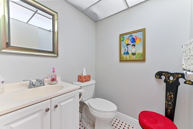 bathroom featuring toilet, baseboards, and vanity