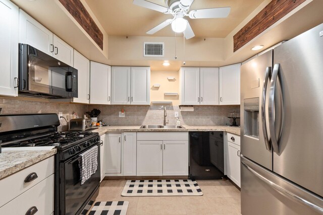 kitchen with tasteful backsplash, visible vents, white cabinets, black appliances, and a sink