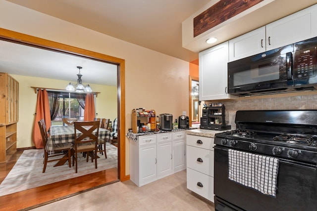 kitchen with a notable chandelier, black appliances, white cabinets, and decorative backsplash