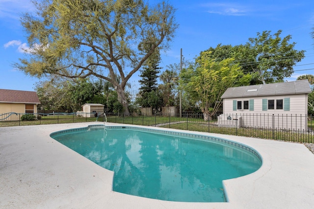 view of pool with a fenced in pool, a yard, a patio area, a fenced backyard, and an outdoor structure