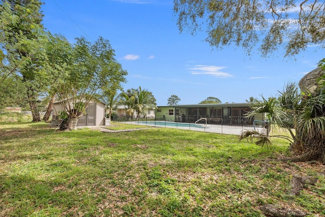 view of yard featuring an outbuilding, fence, and a fenced in pool