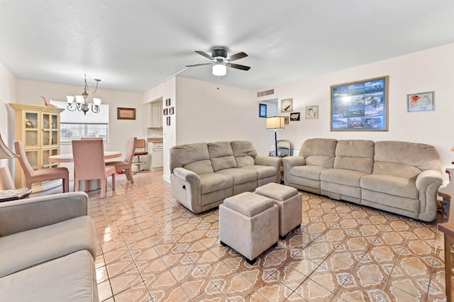 tiled living area featuring ceiling fan with notable chandelier and visible vents