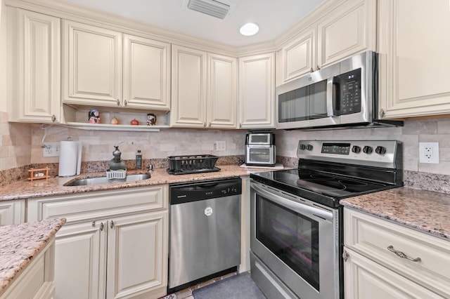 kitchen featuring visible vents, decorative backsplash, appliances with stainless steel finishes, light stone countertops, and open shelves