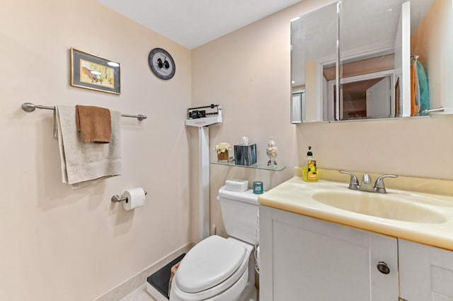 bathroom with vanity, toilet, and baseboards