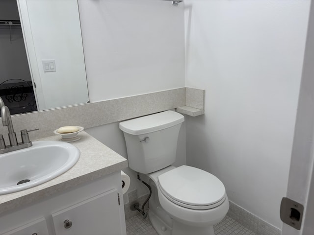 half bath with vanity, toilet, and tile patterned floors