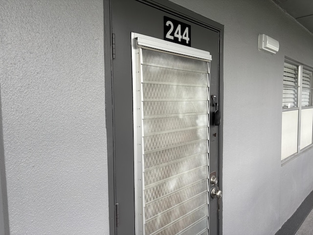 view of exterior entry featuring stucco siding