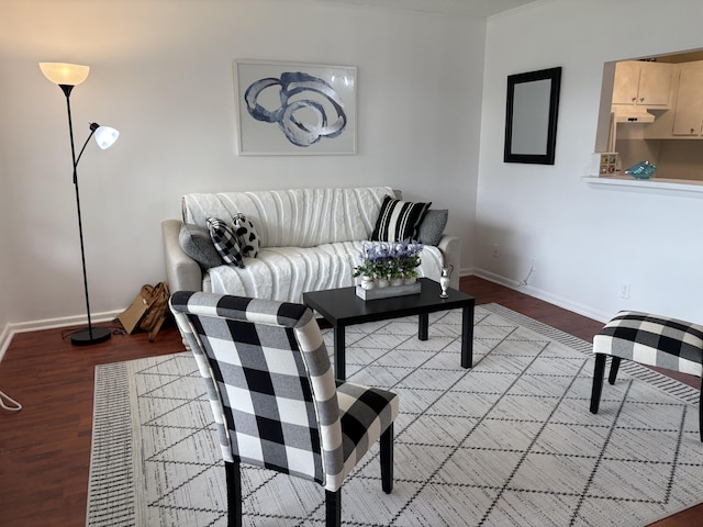 living area with baseboards and wood finished floors