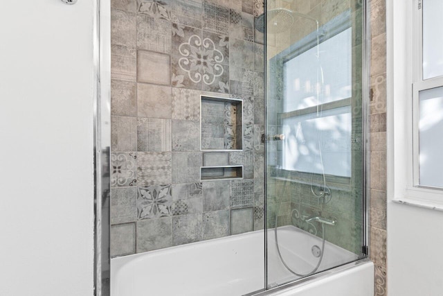 full bath with combined bath / shower with glass door and plenty of natural light