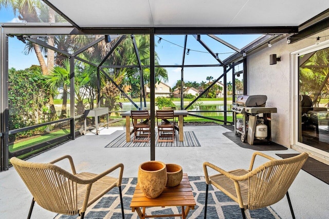 view of patio featuring glass enclosure, outdoor dining area, and grilling area