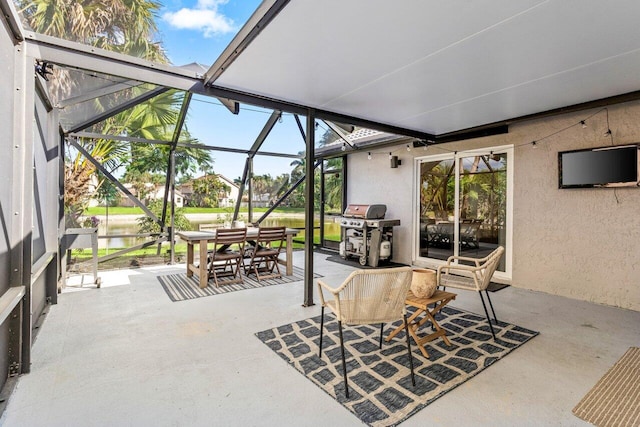 view of patio featuring a lanai, a water view, and area for grilling