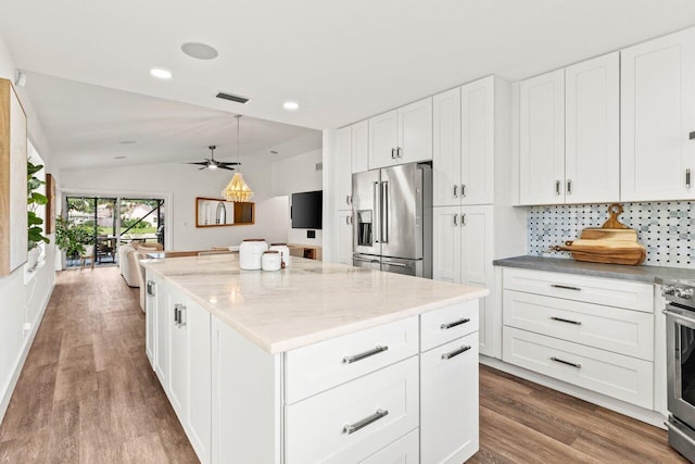 kitchen featuring vaulted ceiling, white cabinetry, open floor plan, and high end fridge