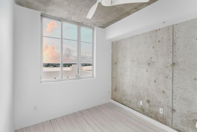 unfurnished room with baseboards and a ceiling fan