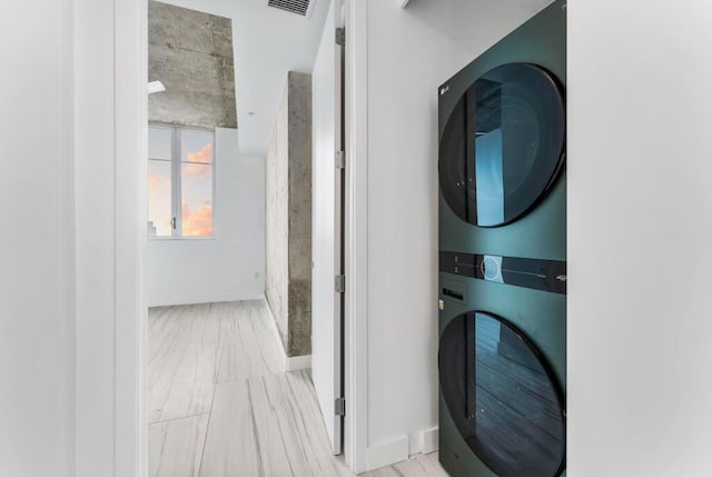 laundry area with laundry area, visible vents, and stacked washer and clothes dryer