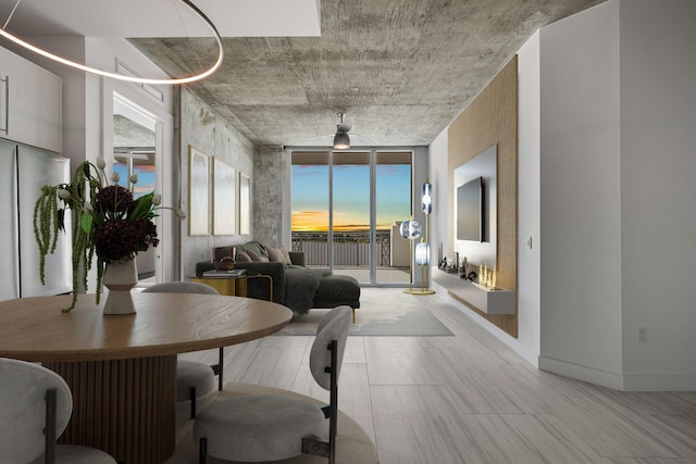 dining room featuring baseboards and a wall of windows