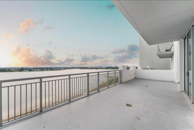 patio terrace at dusk with a balcony and a water view