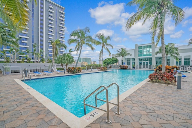 pool with a patio area and fence