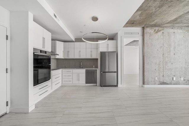 kitchen with visible vents, appliances with stainless steel finishes, a sink, white cabinetry, and backsplash