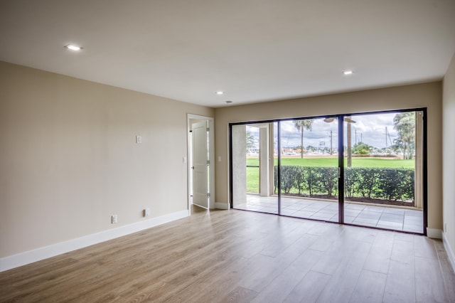 spare room with light wood finished floors, baseboards, and recessed lighting