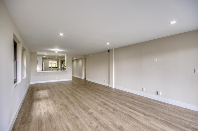 unfurnished living room featuring baseboards, recessed lighting, visible vents, and light wood-style floors