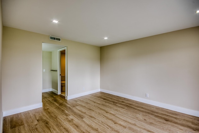 unfurnished room with light wood-type flooring, baseboards, and visible vents