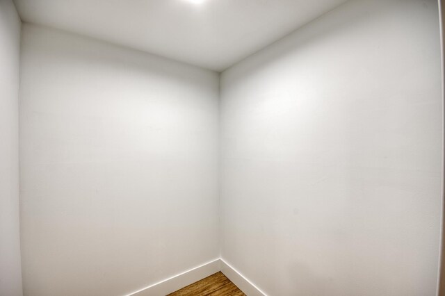 empty room with baseboards and wood finished floors