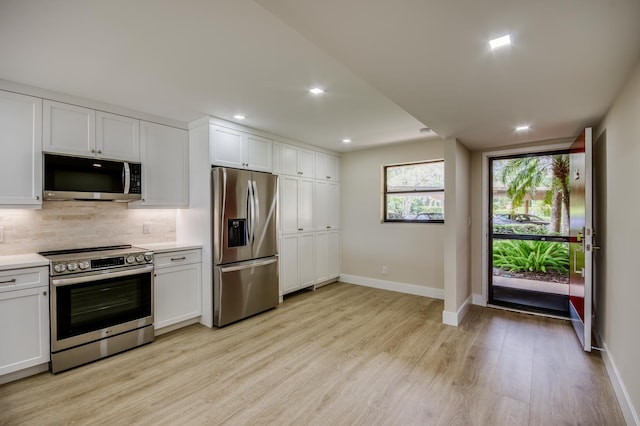 kitchen featuring stainless steel appliances, light countertops, backsplash, and white cabinetry