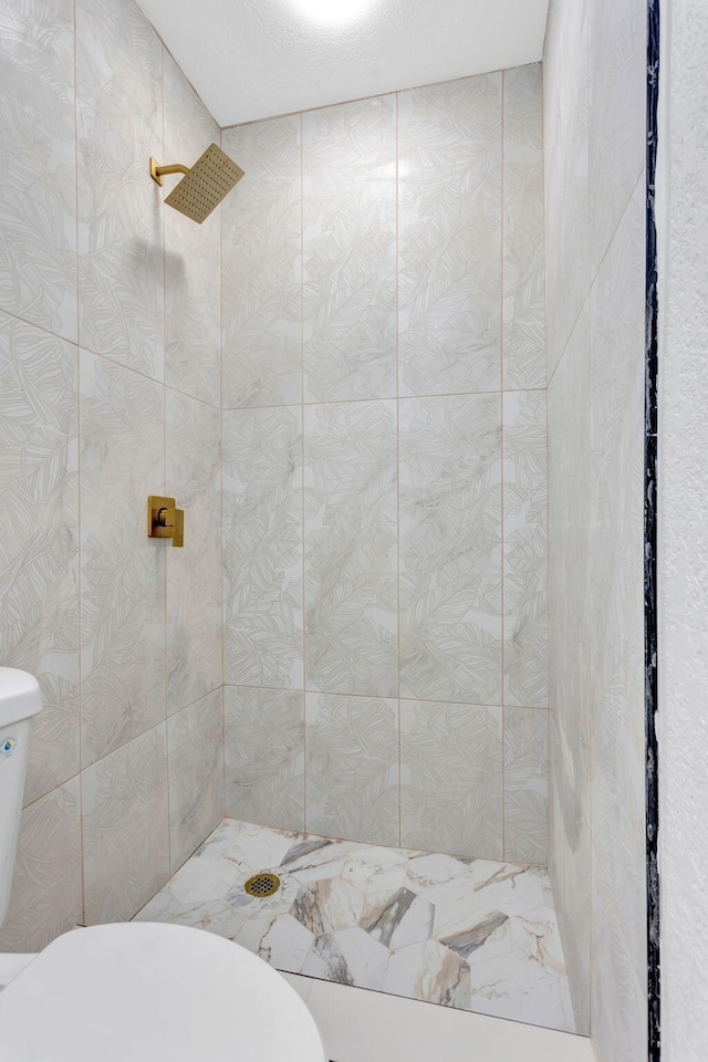 full bath featuring toilet and tiled shower