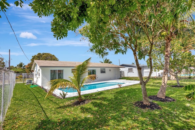 back of house with a fenced backyard, central AC unit, and a yard