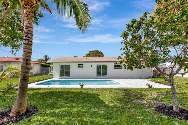 back of property with fence, a yard, a fenced in pool, stucco siding, and a patio area